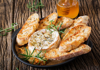 Baked cheese Camembert with rosemary and honey. Tasty food.