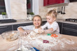 © AnastazjaSoroka - Happy family! A tiny daughter spends time with her mother in the kitchen to bake cookies. Mother's Day.
