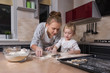© AnastazjaSoroka - Happy family! A tiny daughter spends time with her mother in the kitchen to bake cookies. Mother's Day.