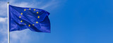 Fototapeta  - Flag of the European Union waving in the wind on flagpole against the sky with clouds on sunny day, banner, close-up