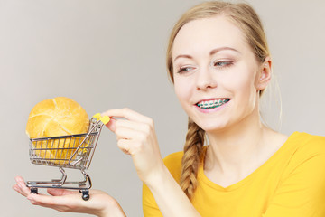 Woman holding shopping cart with bread