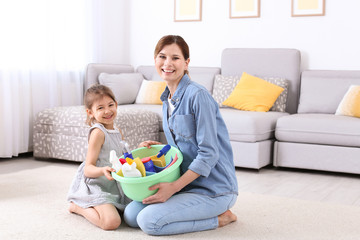 Poster - Housewife and daughter with basket full of detergents on carpet at home