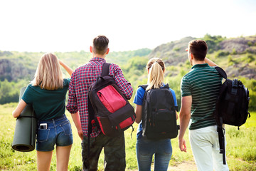 Wall Mural - Group of young people with backpacks in wilderness. Camping season