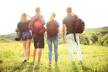 Wall Mural - Group of young people with backpacks in wilderness. Camping season