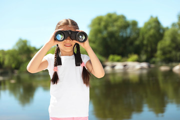 Wall Mural - little girl with binoculars outdoors. summer camp