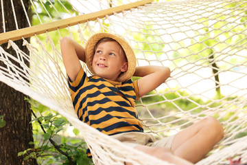 Wall Mural - Little boy resting in hammock outdoors. Summer camp