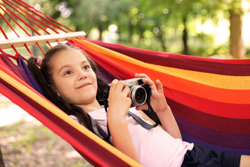 Wall Mural - little girl with camera in hammock outdoors. summer camp