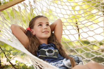 Wall Mural - little girl with camera in hammock outdoors. summer camp
