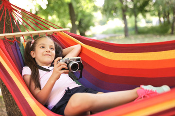 Wall Mural - little girl with camera in hammock outdoors. summer camp