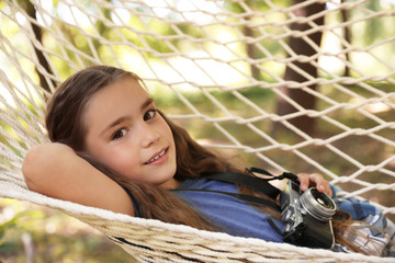 Wall Mural - little girl with camera in hammock outdoors. summer camp