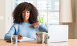 © Krakenimages.com - African american woman studying at home using a computer laptop with surprise face pointing finger to himself