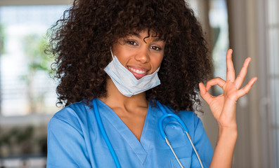 African american woman medical professional doing ok sign with fingers, excellent symbol