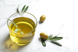 Fototapeta  - Glass with fresh olive oil on table
