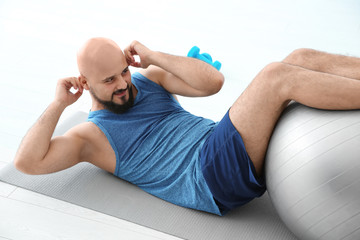 Sticker - Overweight man doing exercise with fitness ball in gym