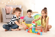 © New Africa - Cute little children playing with building blocks on floor, indoors