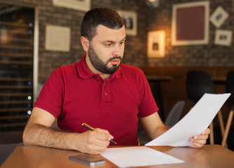 Wall Mural - Worried man looking at papers