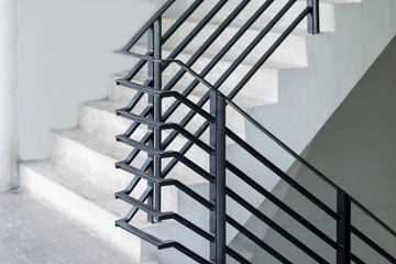 Stairway with black metallic banister in a new modern building architecture
