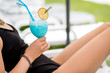 © rh2010 - Woman in black swimsuit with beautiful summer cocktail relaxing outdoors, close-up view