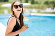 © rh2010 - Portrait of a young woman in black swimsuit relaxing with summer cocktail sitting on the poolside outdoors