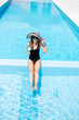 © rh2010 - Young woman in black swimsuit and sun hat relaxing with cocktail in the swimming pool outdoors