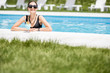 © rh2010 - Portrait of a beautiful woman in black swimsuit relaxing with cocktail at the swimming pool outdoors