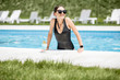 © rh2010 - Portrait of a beautiful woman in black swimsuit relaxing with cocktail at the swimming pool outdoors
