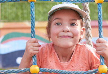 A cute caucasian girl is playing on the playground.