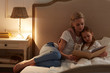 © pressmaster - Cute little girl napping in her bed with mother reading book near by in bedroom