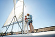 © pressmaster - Two active men preparing sail of yacht while going to have small voyage in the sea