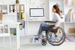 © pressmaster - Blurry silhouette of office worker moving on wheelchair inside modern office
