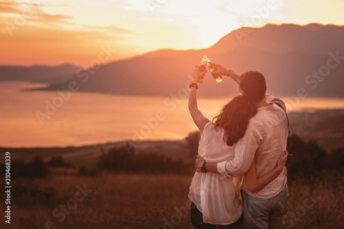 Cuadros en Lienzo Young couple having good times in nature looking at the sunset on Boka Bay
