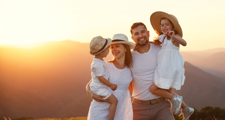 Wall Mural - Happy family: mother, father, children son and daughter on sunset