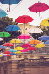 Multi-colored umbrellas background. Colorful umbrellas floating above the street. Street decoration.