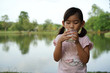 © akachai studio - Asian kids little girl read a book In the garden