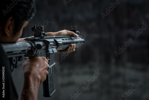 Fotomural Man holding gun aiming pistol in shooting range
