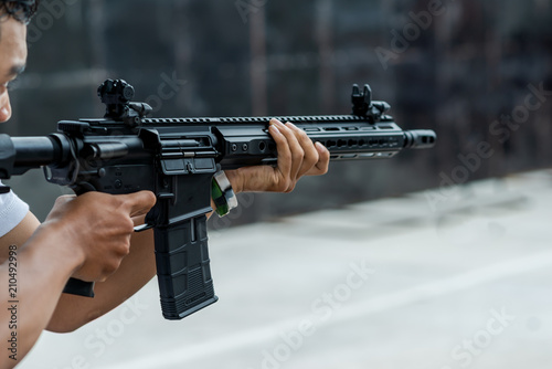 Cuadros en Lienzo Man holding gun aiming pistol in shooting range