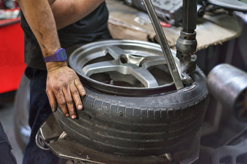 Wall Mural - Professional mechanic using machine for tyre change.