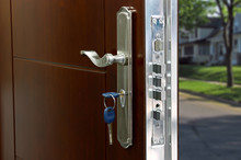 Open Door Of A Family Home. Close-up Of The Lock With Your Keys On An Armored Door. Security.