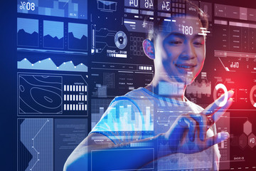 Easy technologies. Cheerful enthusiastic programmer feeling happy and smiling while standing in front of a transparent screen and touching the icons on it