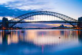 Fototapeta Most - Mighty construction of harbor harbour bridge during sunset sky to downtown city center centre Sydney for holiday and couple romantic honeymoon