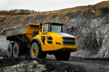 Articulated dump truck on the road in an open coal mine.