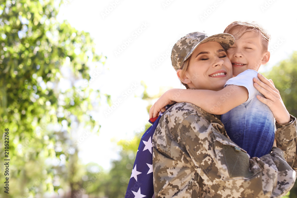 American soldier with her son outdoors. Military service - obrazy, fototapety, plakaty 