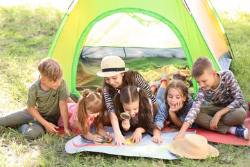 Wall Mural - little children with map near tent outdoors. summer camp