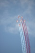 Formacja szybkich samolotów, w biało-czerwonych barwach,  leci bardzo blisko siebie, puszczając dym z każdego samolotu, dym biały i czerwony