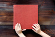 kid holding hands on brown leather covered wedding album or book