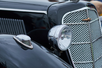 The front light of an old black car