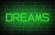 Word Dreams written with neon letters at brick wall background