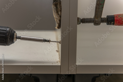 A Carpenter Screws Kitchen Cabinets He Fixed The Cabinets With A