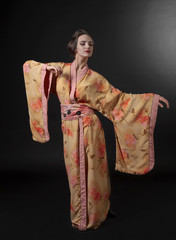 Dancing woman in traditional Japanese kimono on a black background.