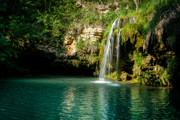 waterfall and a beautiful lagoon lake for relaxing in the summer forest.